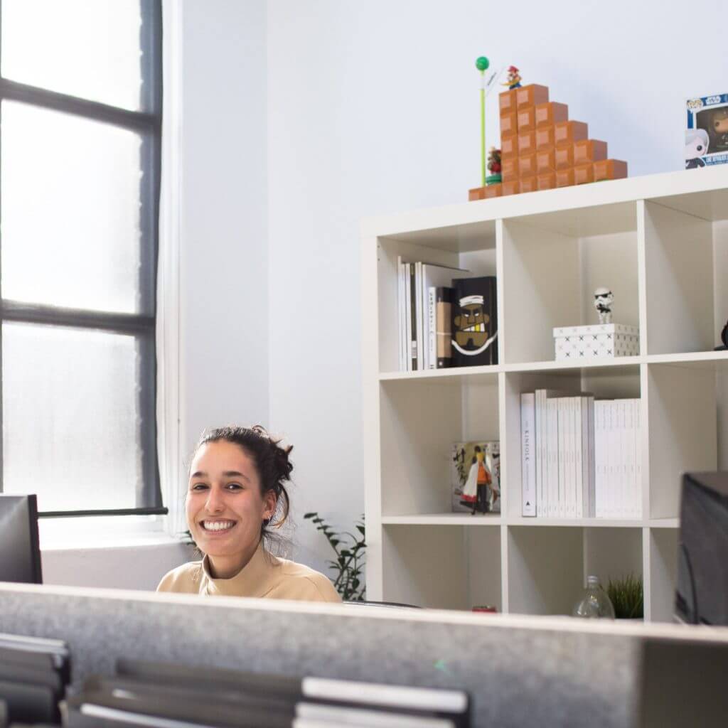 Woman sitting at reception desk smiling.