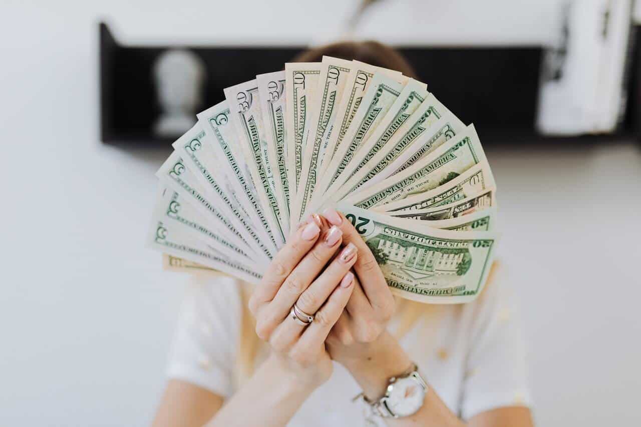 woman holding twenty dollar bills in her hands