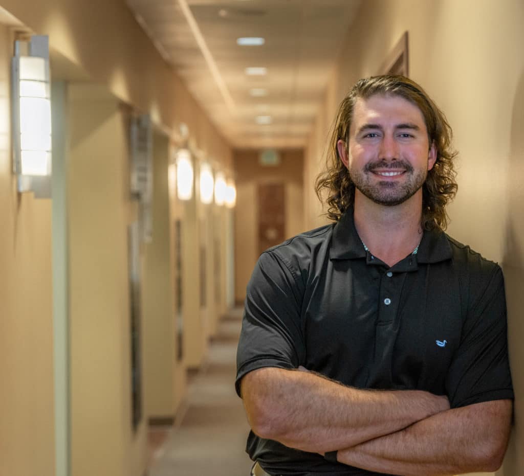 Dentist standing in office with arms folded