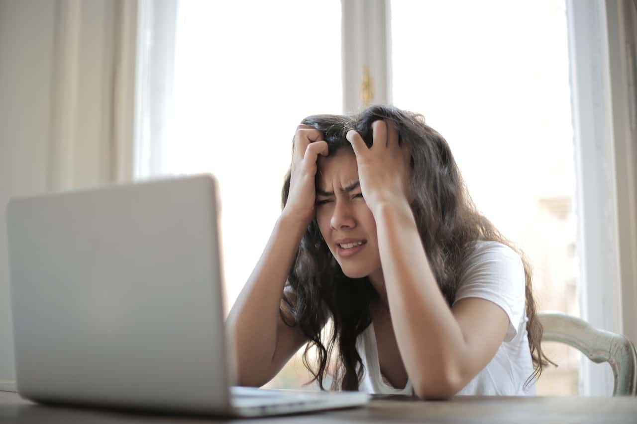 woman looking at computer with frustration