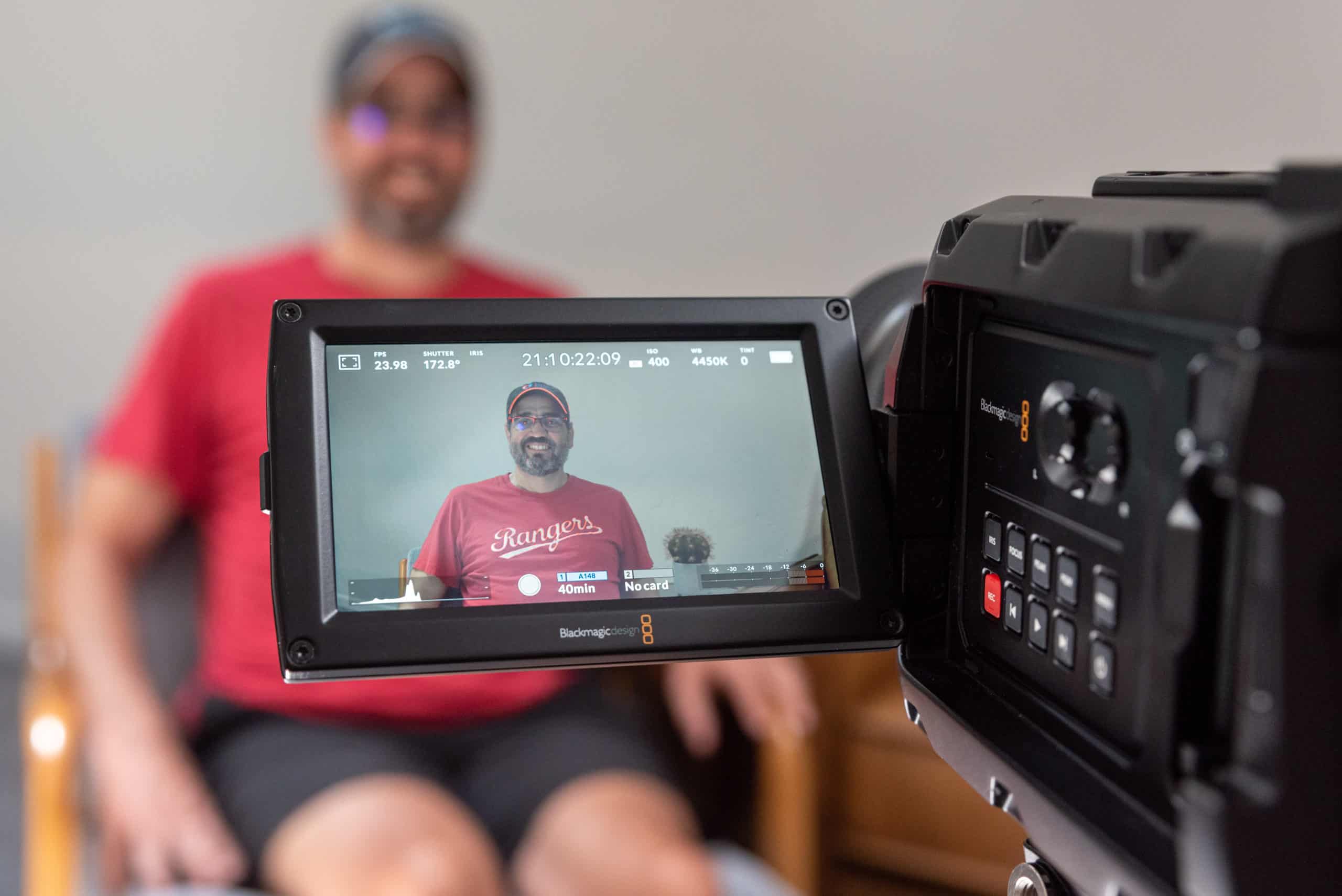 Image of person being interviewed through a video camera screen.