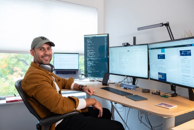 Founder, Andre, from Pain-Free Dental Marketing at his office desk working on web design and development